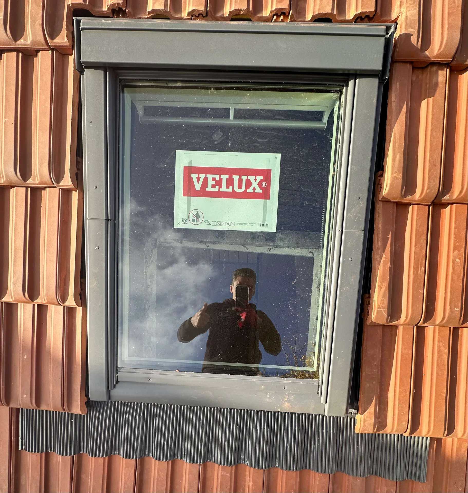 Fenêtre de toit VELUX posée sur une couverture en tuiles, vue rapprochée